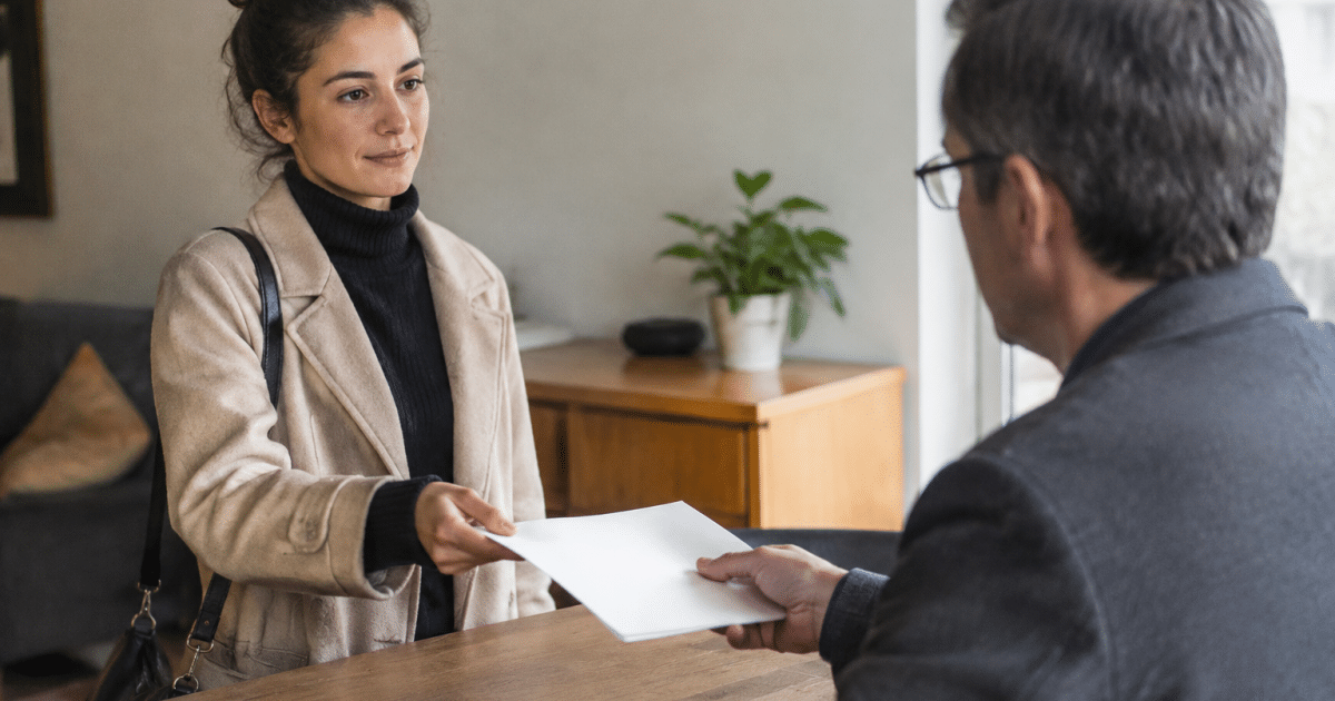 Locataire remettant document de resiliation au proprietaire immobilier